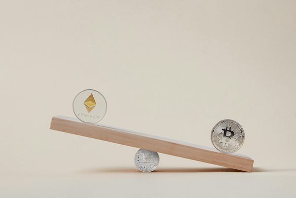 Wooden balance scale with Ethereum and Bitcoin coins
