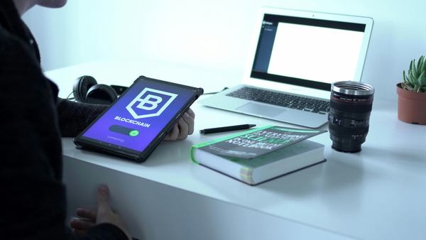 Tablet with blockchain app on a bright workspace