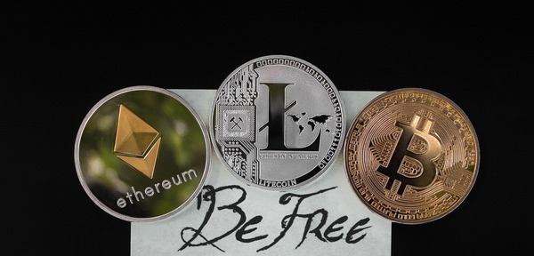 Ethereum, Litecoin and Bitcoin coins on a note reading Be Free