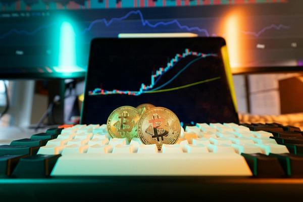 Crypto coins on a backlit keyboard in front of a chart