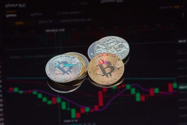 Bitcoin and silver coins in front of a red and green price chart