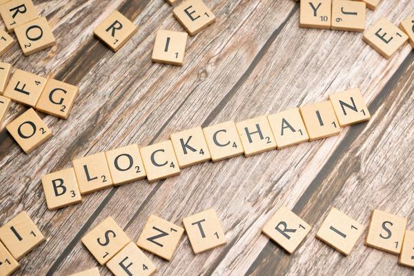 Wooden letter tiles spelling blockchain on a rustic table