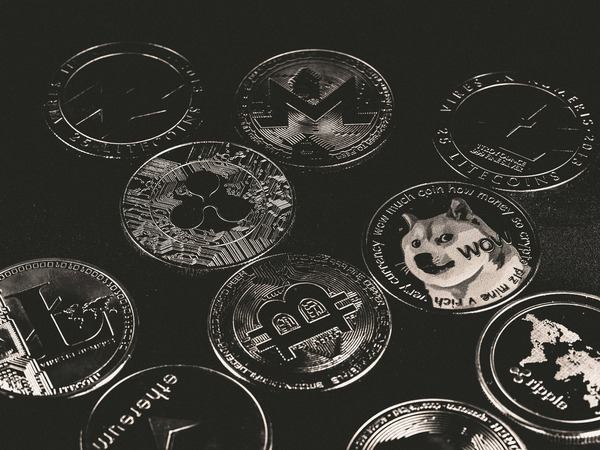 Engraved silver crypto coins on a black surface