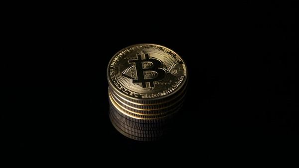 Stack of gold Bitcoin coins on a black background
