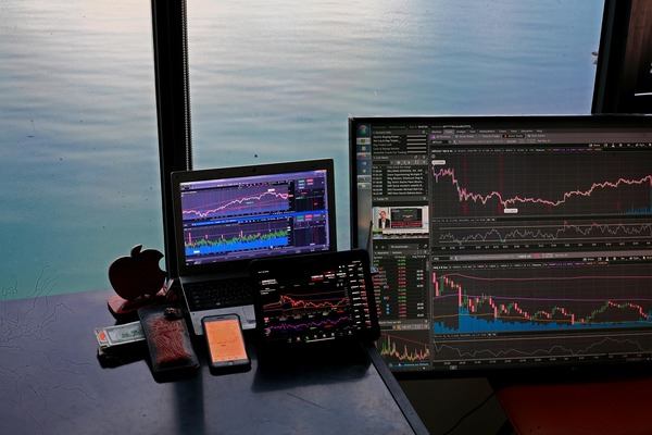 Trading desk with crypto charts in front of a sea view window