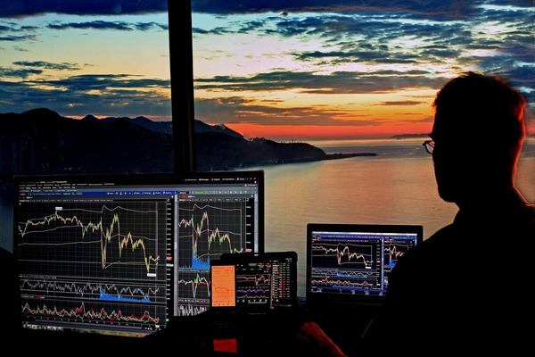 Trader silhouette watching crypto charts at sunset