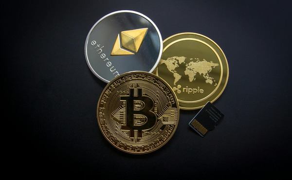 Ethereum, Bitcoin and Ripple coins on a dark surface