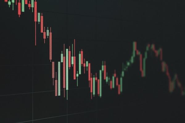 Red and green candlestick price chart on a dark screen