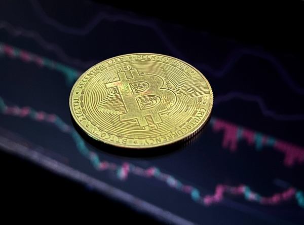 Gold crypto coin lying on a glowing price chart