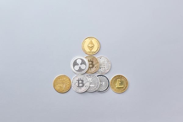 Pyramid of assorted crypto coins on a light background