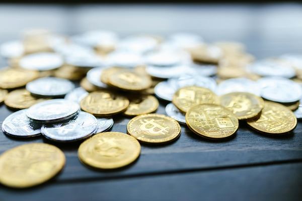 Scattered gold and silver crypto coins on a dark table