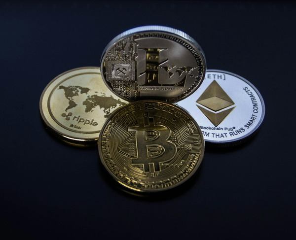 Bitcoin, Ethereum and Ripple coins on a dark surface