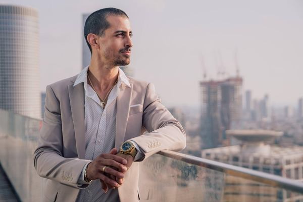Confident man in a suit on a balcony overlooking the city